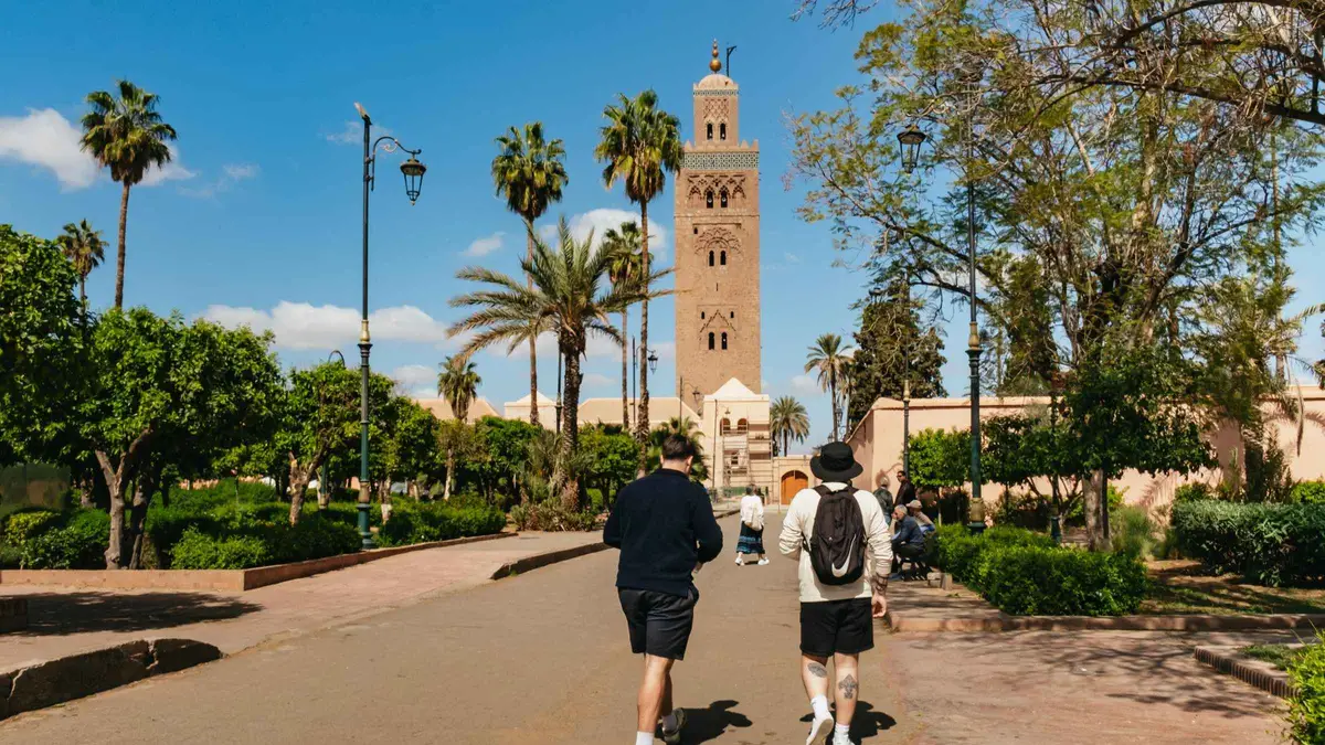 Group walking a narrow medina lane towards the Saadian Tombs on a Saadian Tombs and Bahia Palace guided tour in Marrakech